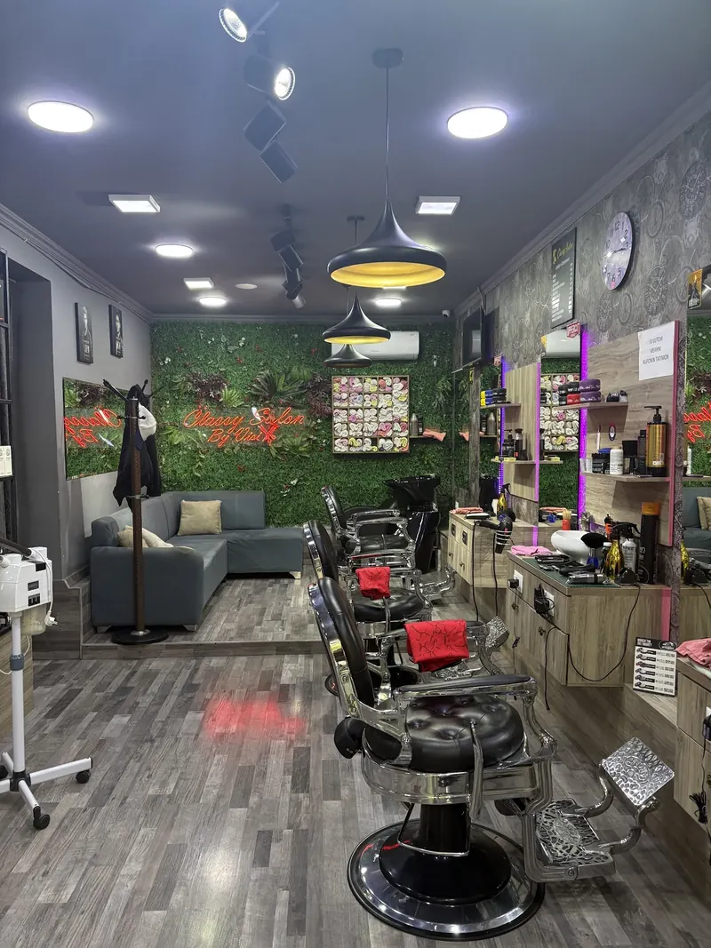 The long room of the shop: barber chairs, sofa and the green wall