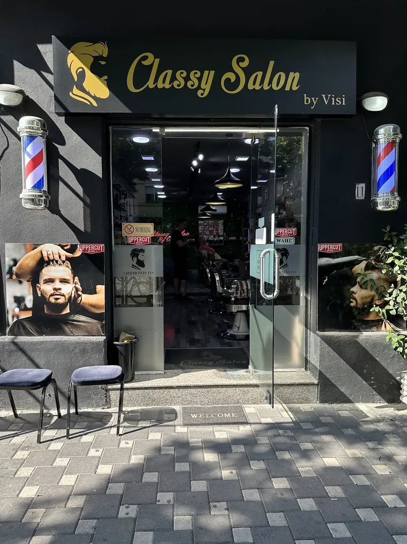 The shopfront by day with its gold sign and barber poles
