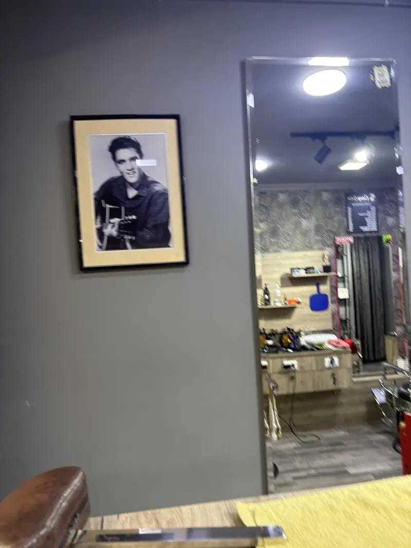 A framed black-and-white portrait beside a tall mirror